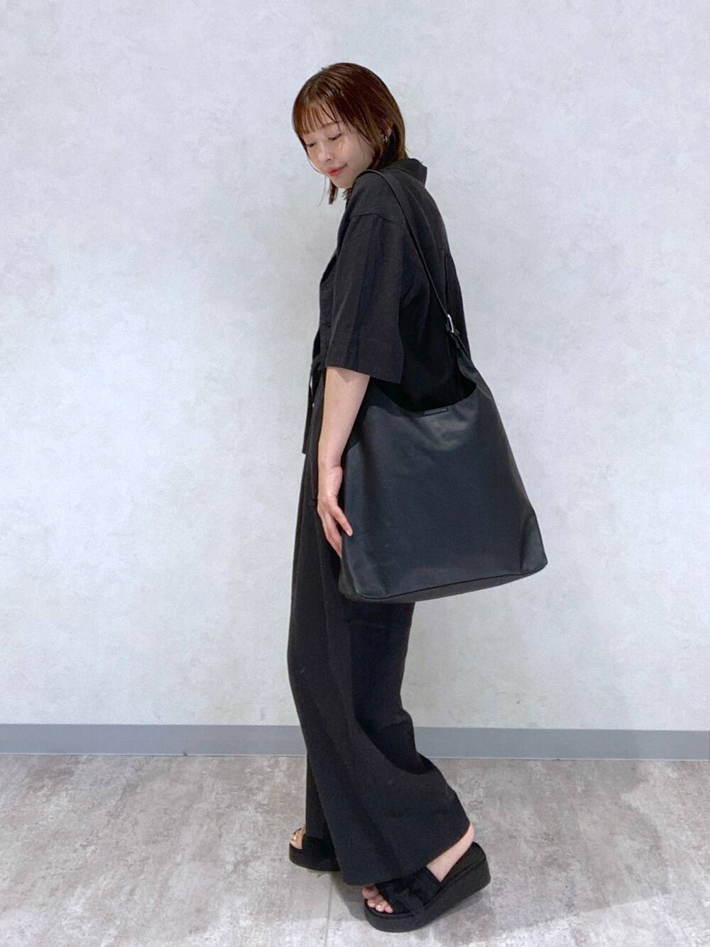 ブラック系のサンダル、ブラック系のショルダーバッグ、ブルー系のタンクトップを着用したレディースの春コーディネートの4枚目の写真