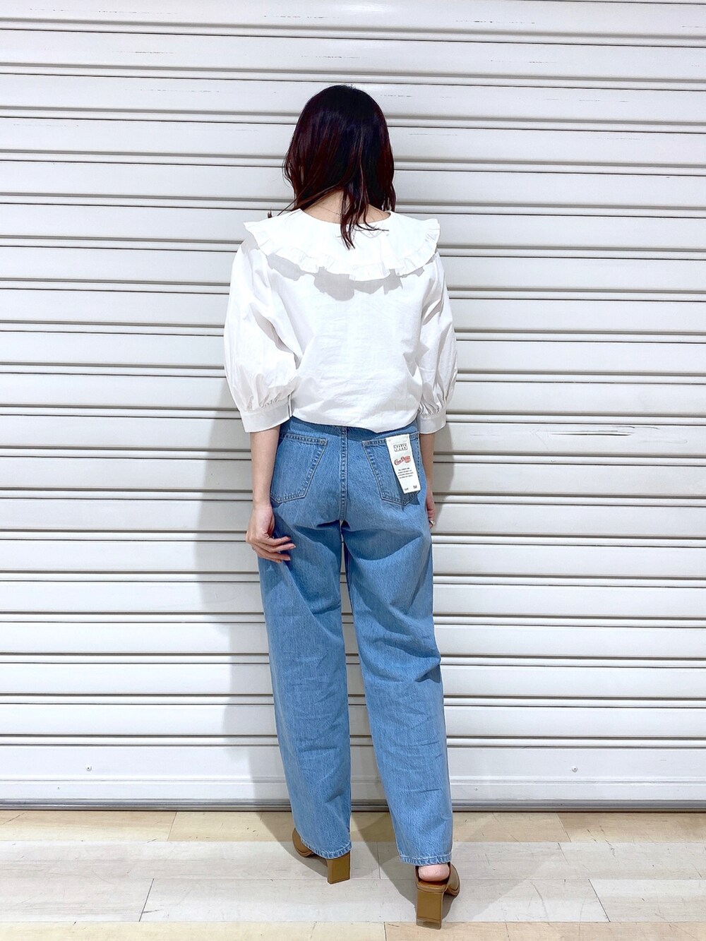 ブルー系のデニムパンツ、ブラック系のサンダルを着用したレディースの春コーディネートの4枚目の写真