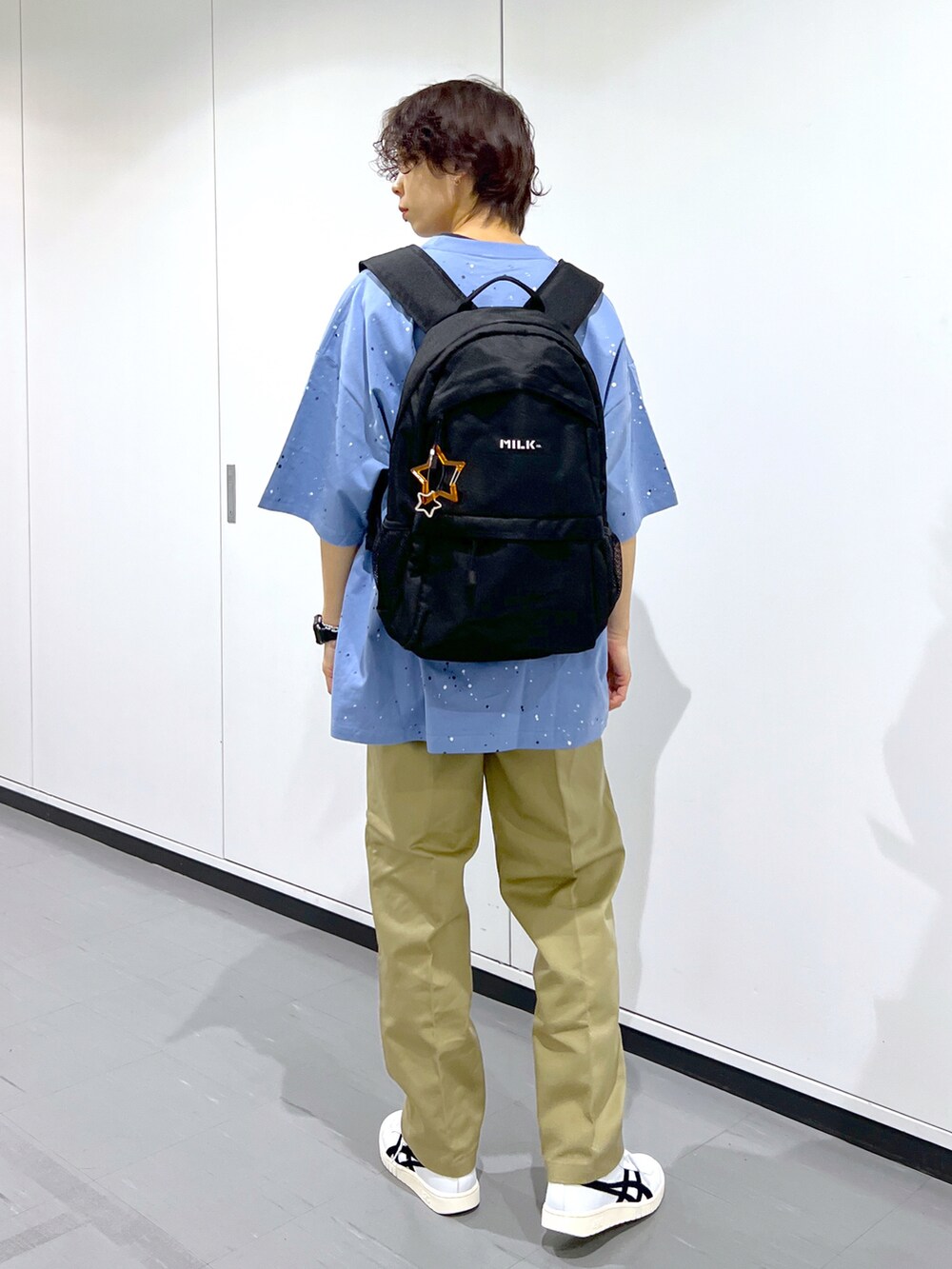 ブルー系のTシャツ/カットソー、ベージュ系のその他パンツ、ブラック系のバックパック/リュックを着用したレディースの春コーディネートの2枚目の写真