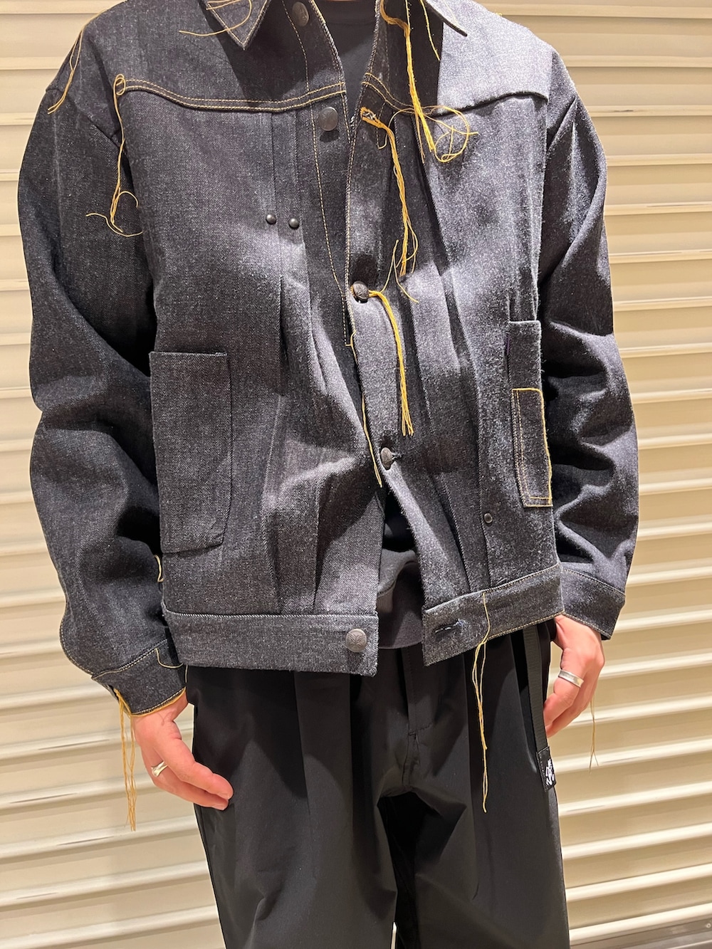 ブルー系のデニムジャケット、ブラック系のスニーカー、ブラック系のその他パンツを着用したメンズの春コーディネートの2枚目の写真