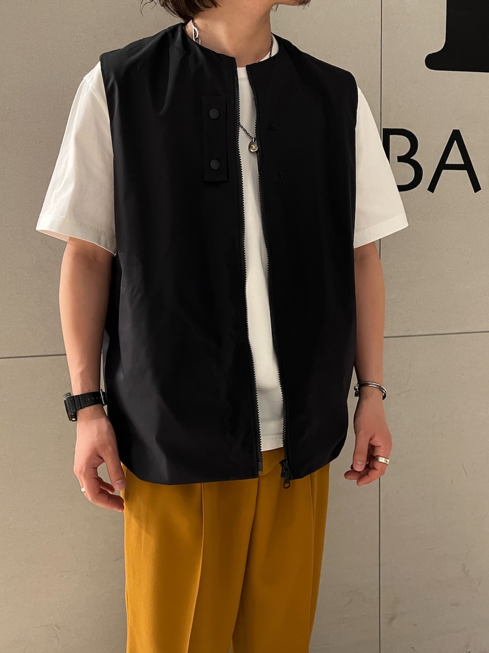 ホワイト系のTシャツ/カットソー、オレンジ系のスラックス、その他のスニーカーを着用したメンズの春コーディネートの2枚目の写真
