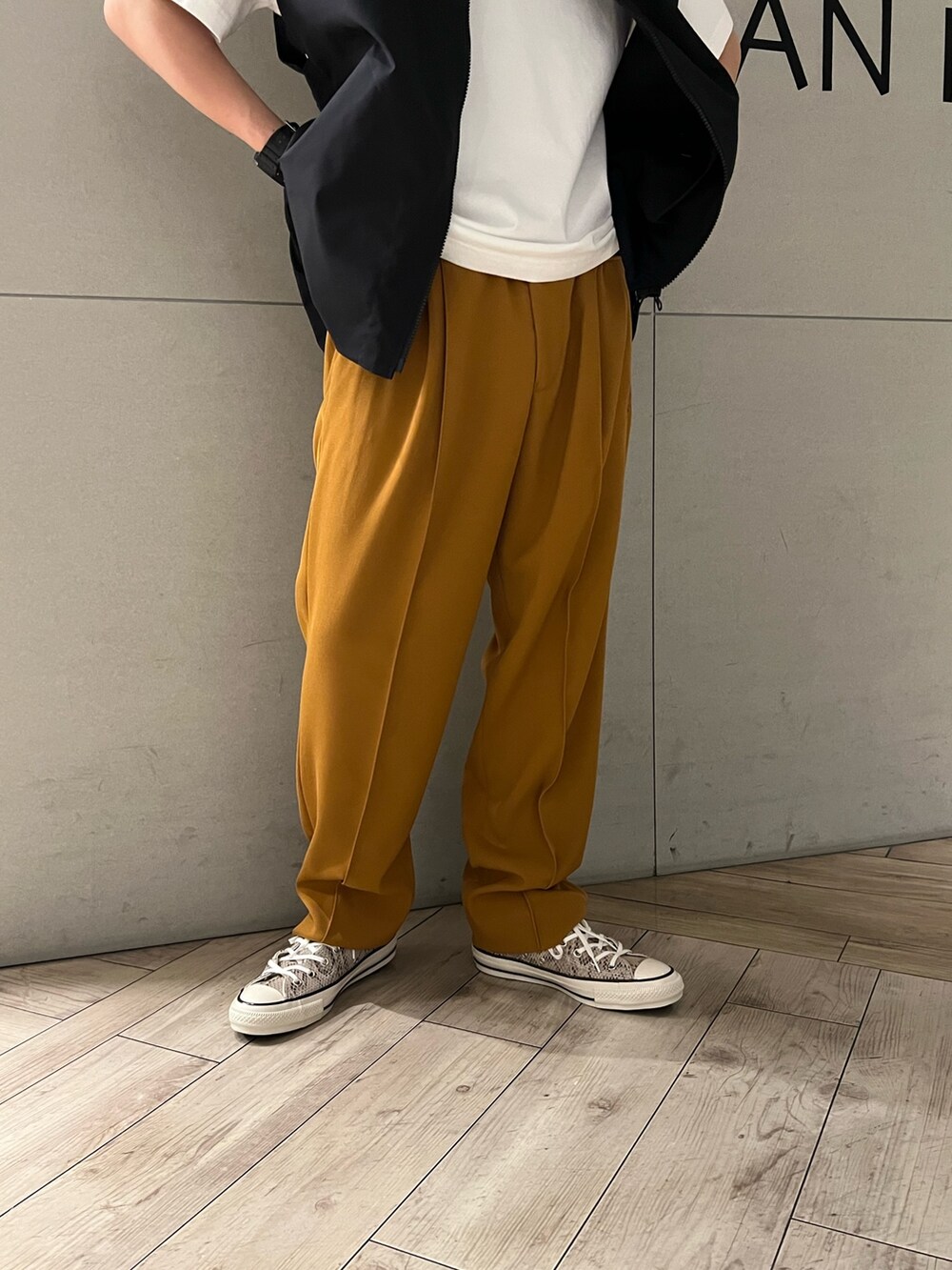 ホワイト系のTシャツ/カットソー、オレンジ系のスラックス、その他のスニーカーを着用したメンズの春コーディネートの4枚目の写真
