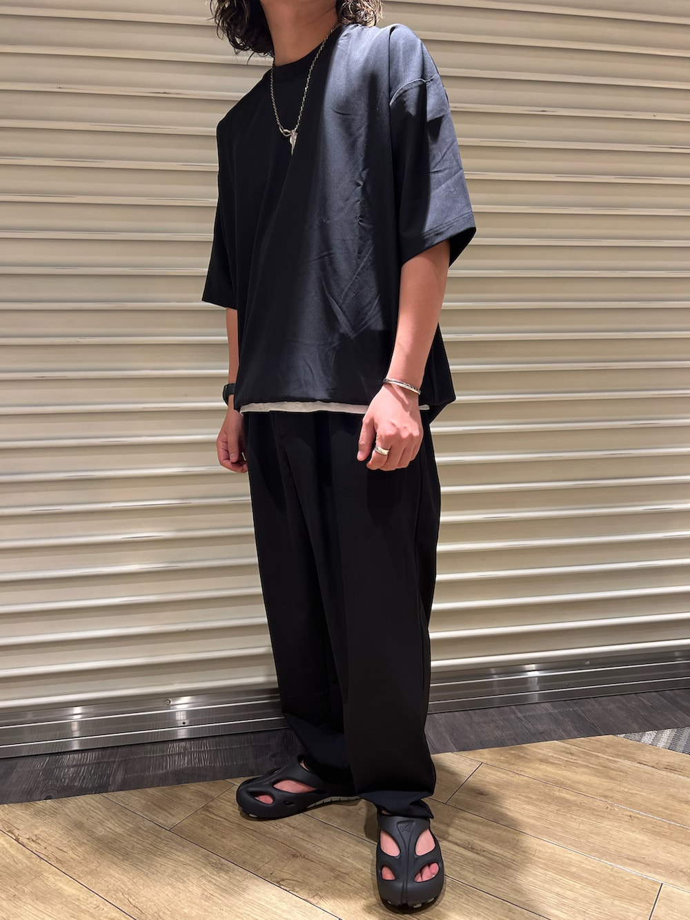 ブラック系のサンダル、ブラック系のTシャツ/カットソー、ブラック系のその他パンツを着用したメンズの夏コーディネートの3枚目の写真