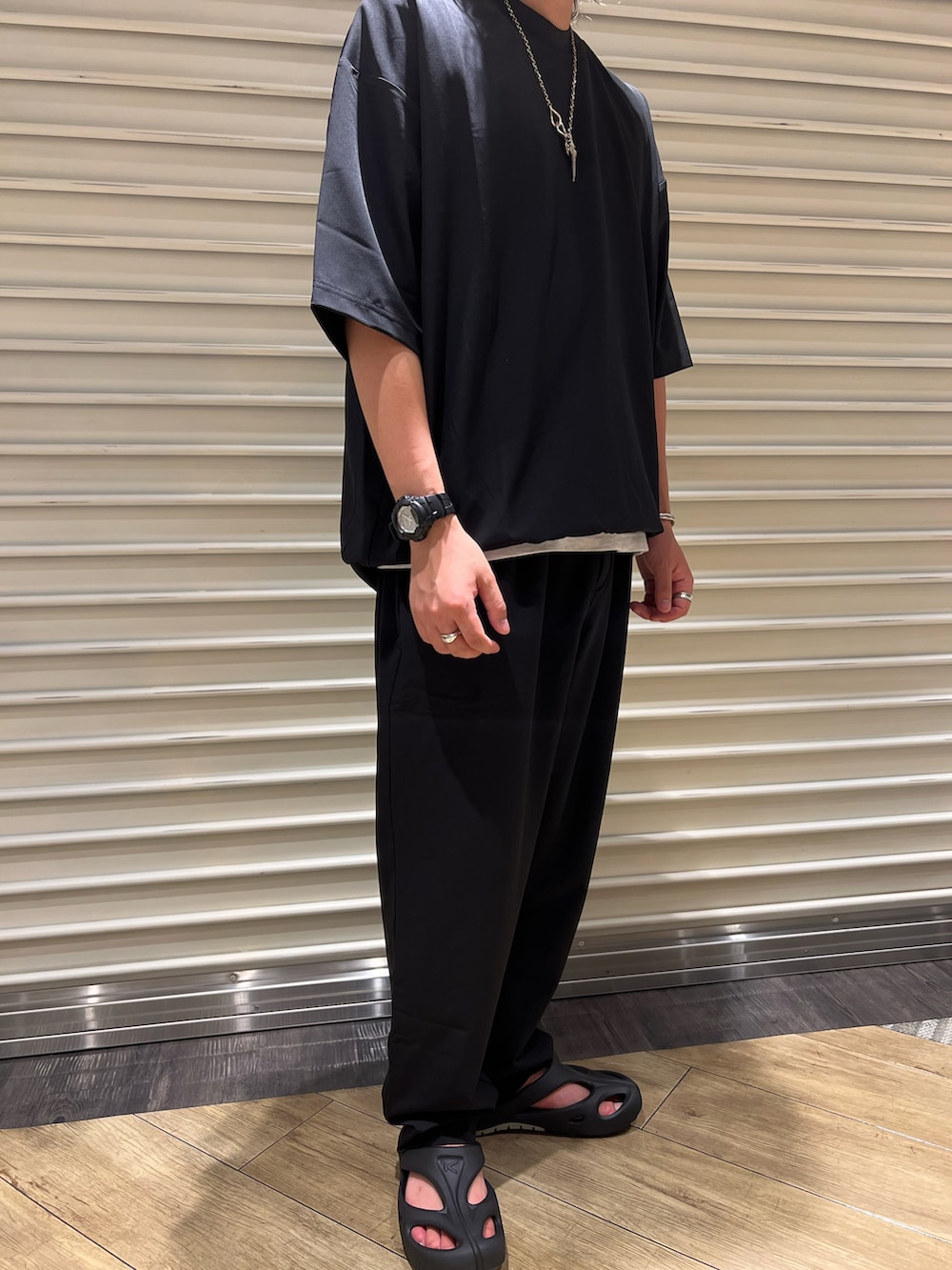 ブラック系のサンダル、ブラック系のTシャツ/カットソー、ブラック系のその他パンツを着用したメンズの夏コーディネートの2枚目の写真