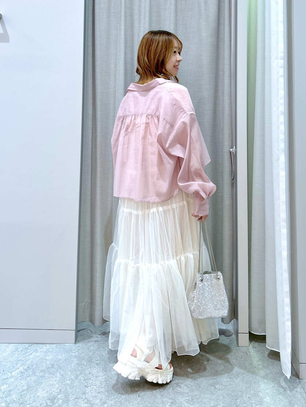 ホワイト系のワンピース、ピンク系のシャツ/ブラウス、シルバー系のショルダーバッグを着用したレディースの夏コーディネートの3枚目の写真