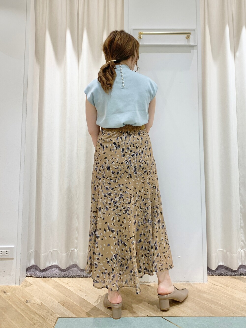 ブルー系のニット/セーター、イエロー系のスカート、ブラック系のショルダーバッグを着用したレディースの夏コーディネートの2枚目の写真