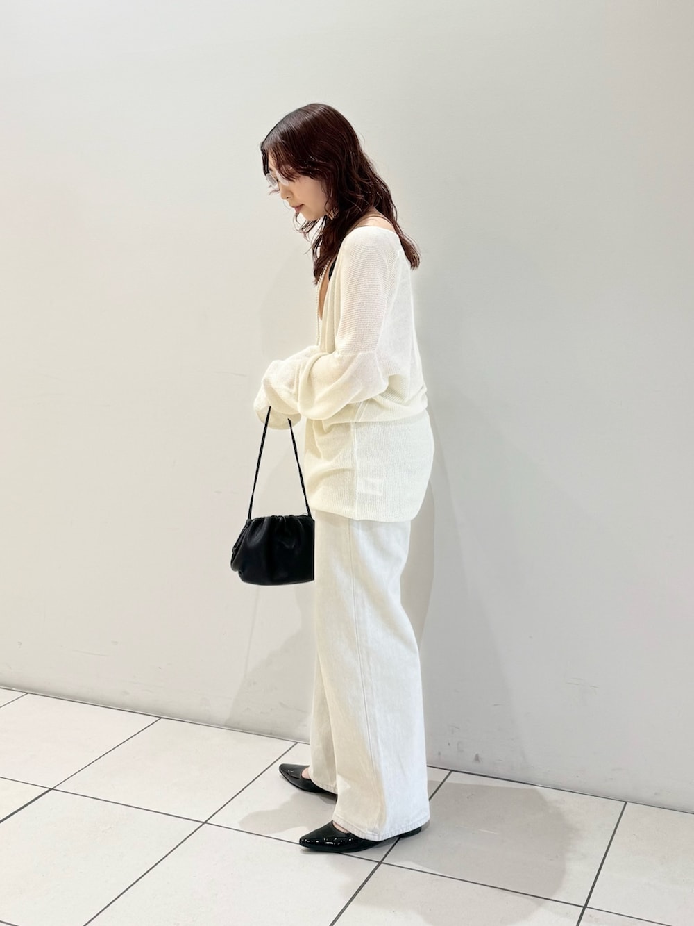 ブラック系のパンプス、オレンジ系のタンクトップ、ホワイト系のニット/セーターを着用したレディースの春コーディネートの4枚目の写真