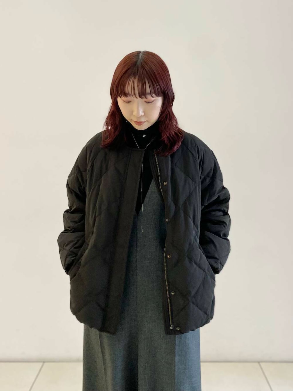 ブラック系のTシャツ/カットソー、ブラック系のダウンジャケット/コート、グレー系のサロペット/オーバーオールを着用したレディースの冬コーディネートの5枚目の写真