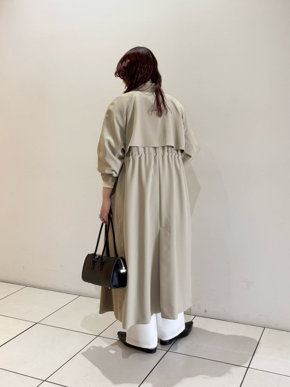 ベージュ系のトレンチコート、ホワイト系のニット/セーター、ブルー系のシャツ/ブラウスを着用したレディースの冬コーディネートの5枚目の写真