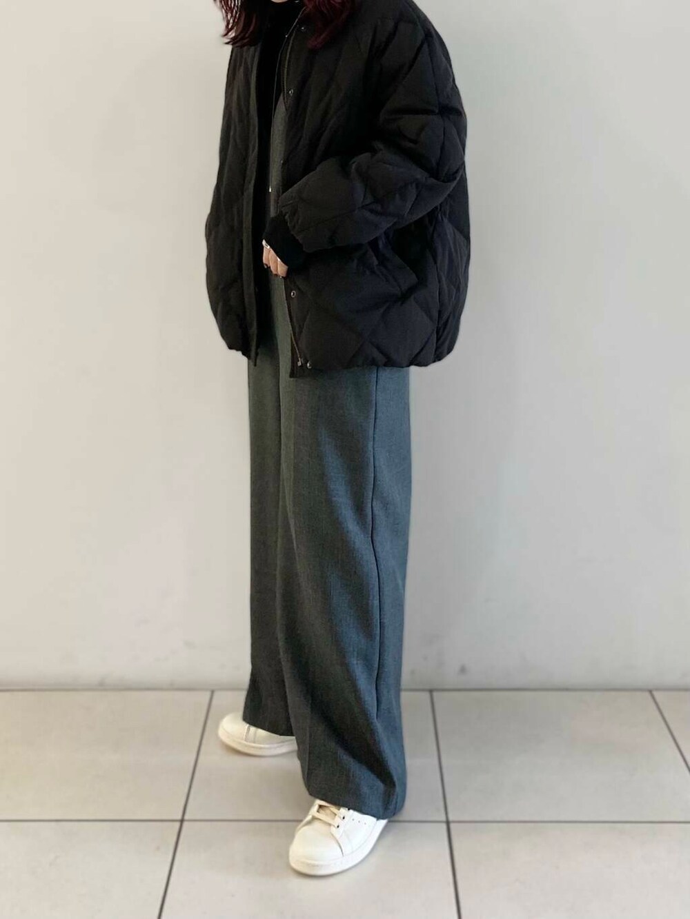 ブラック系のTシャツ/カットソー、ブラック系のダウンジャケット/コート、グレー系のサロペット/オーバーオールを着用したレディースの冬コーディネートの6枚目の写真