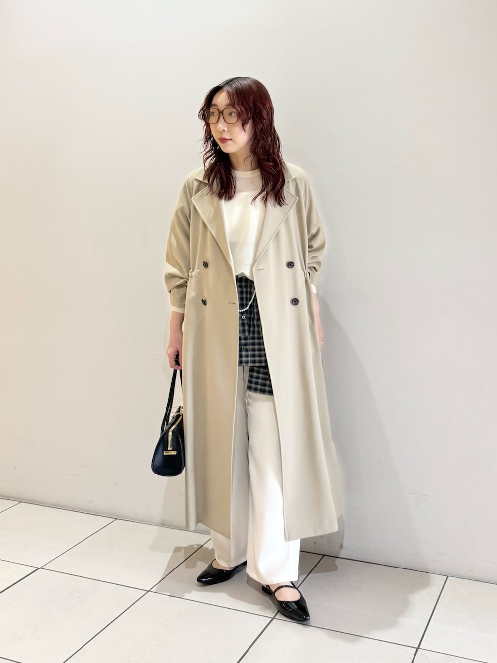 ベージュ系のトレンチコート、ホワイト系のニット/セーター、ブルー系のシャツ/ブラウスを着用したレディースの冬コーディネートの3枚目の写真