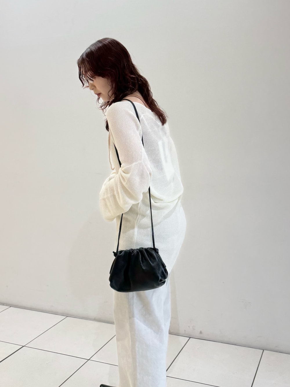 ブラック系のパンプス、オレンジ系のタンクトップ、ホワイト系のニット/セーターを着用したレディースの春コーディネートの8枚目の写真