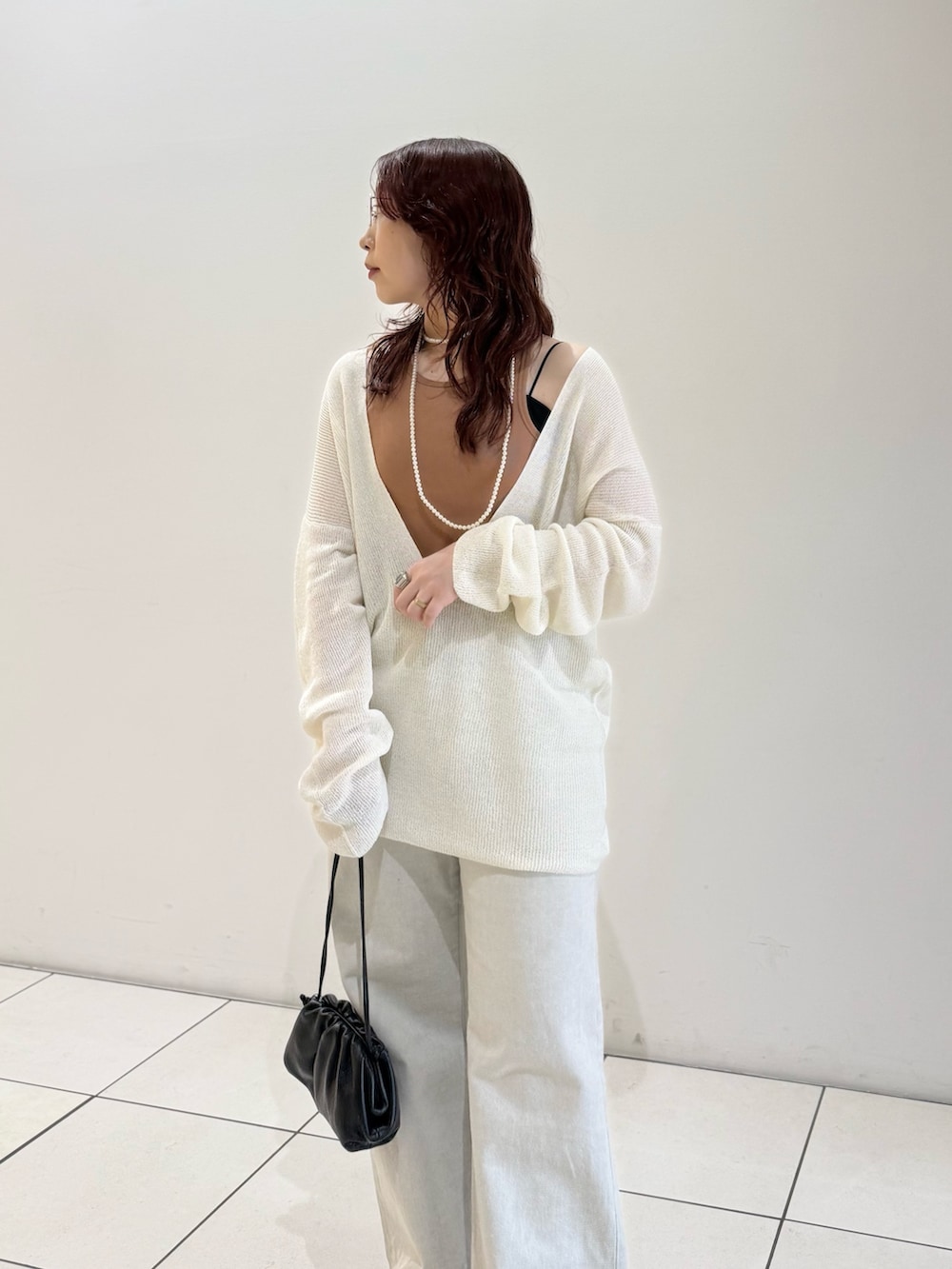 ブラック系のパンプス、オレンジ系のタンクトップ、ホワイト系のニット/セーターを着用したレディースの春コーディネートの6枚目の写真