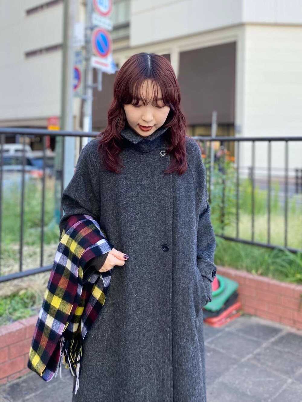 ブラック系のステンカラーコート、グリーン系のニット/セーター、ブラック系のブーツを着用したレディースの秋コーディネートの5枚目の写真