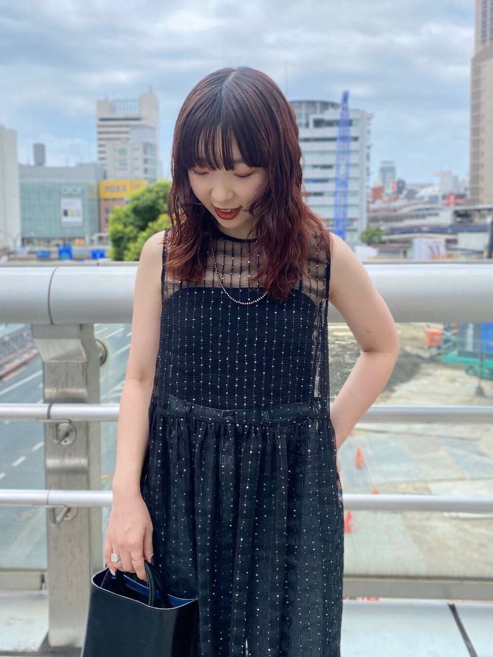 ブラック系のキャミソール、ブラック系のデニムパンツ、ブラック系のワンピースを着用したレディースの夏コーディネートの5枚目の写真