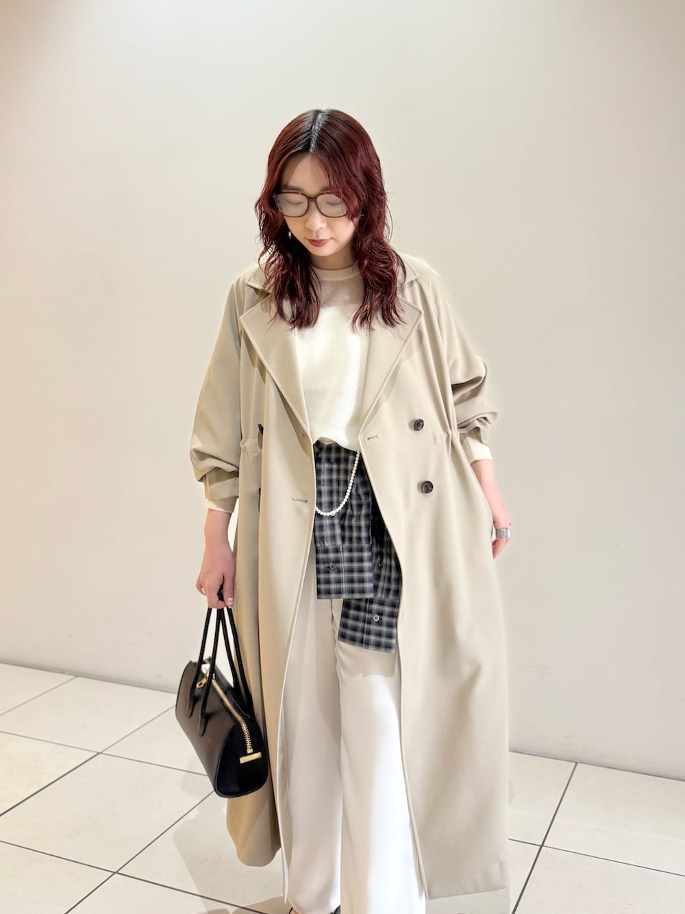 ベージュ系のトレンチコート、ホワイト系のニット/セーター、ブルー系のシャツ/ブラウスを着用したレディースの冬コーディネートの6枚目の写真