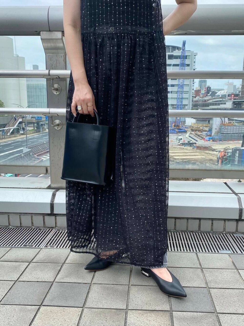 ブラック系のキャミソール、ブラック系のデニムパンツ、ブラック系のワンピースを着用したレディースの夏コーディネートの6枚目の写真