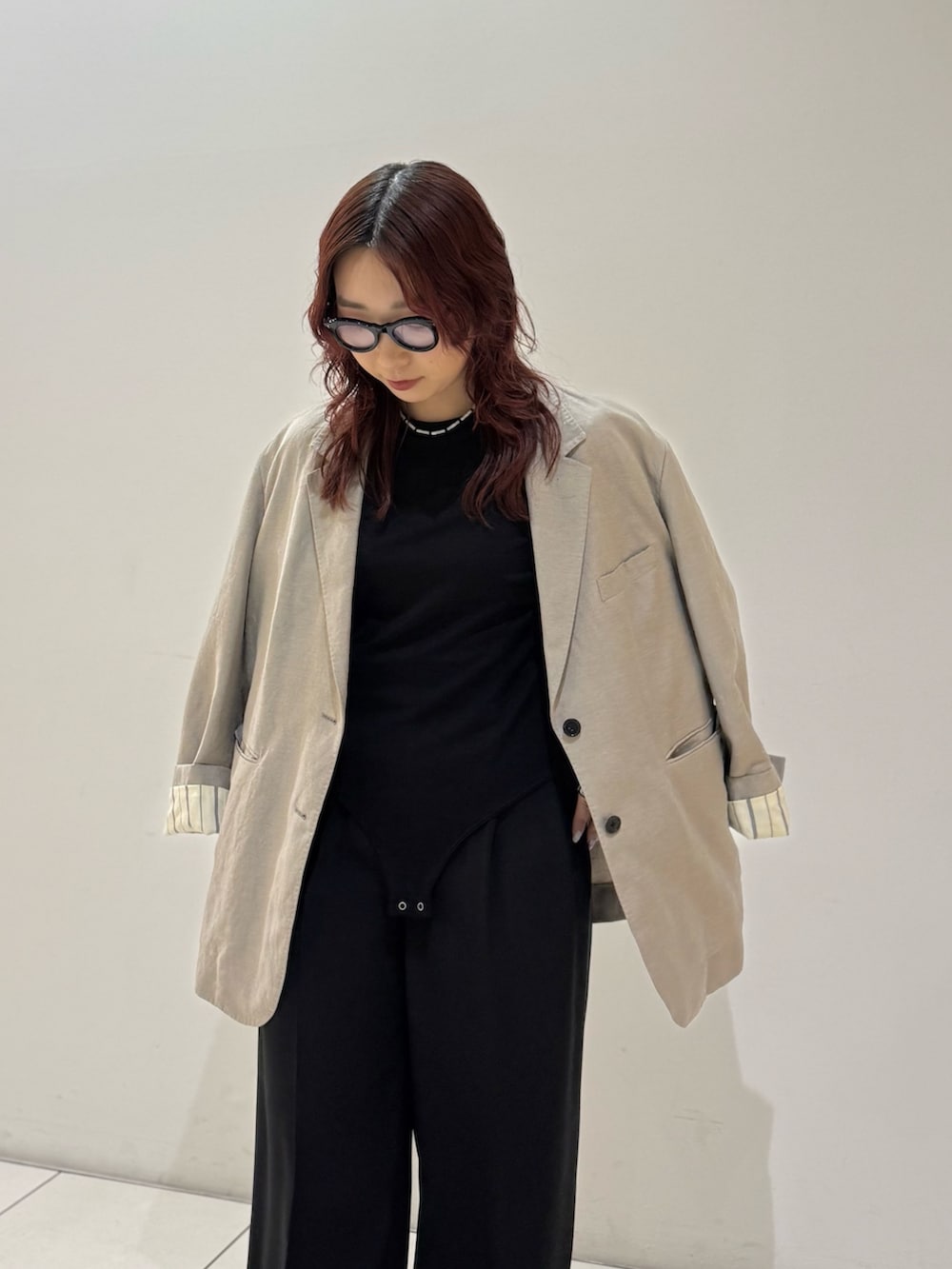 ブラック系のその他パンツ、ブラック系のTシャツ/カットソー、ベージュ系のテーラードジャケットを着用したレディースの冬コーディネートの5枚目の写真