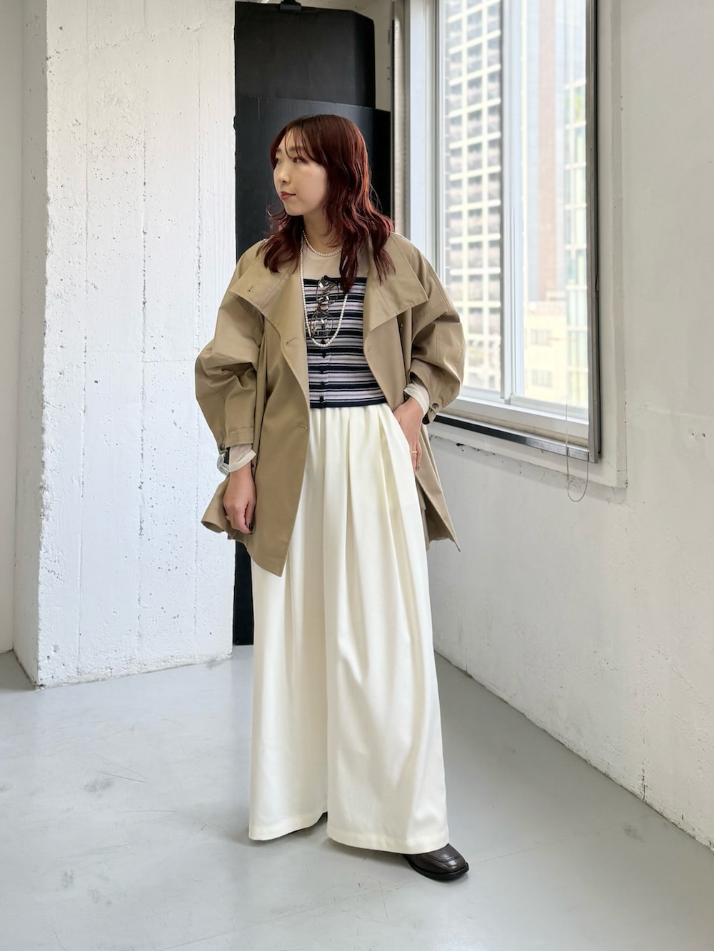 ホワイト系のその他パンツ、ベージュ系のトレンチコート、ブルー系のニット/セーターを着用したレディースの冬コーディネートの4枚目の写真