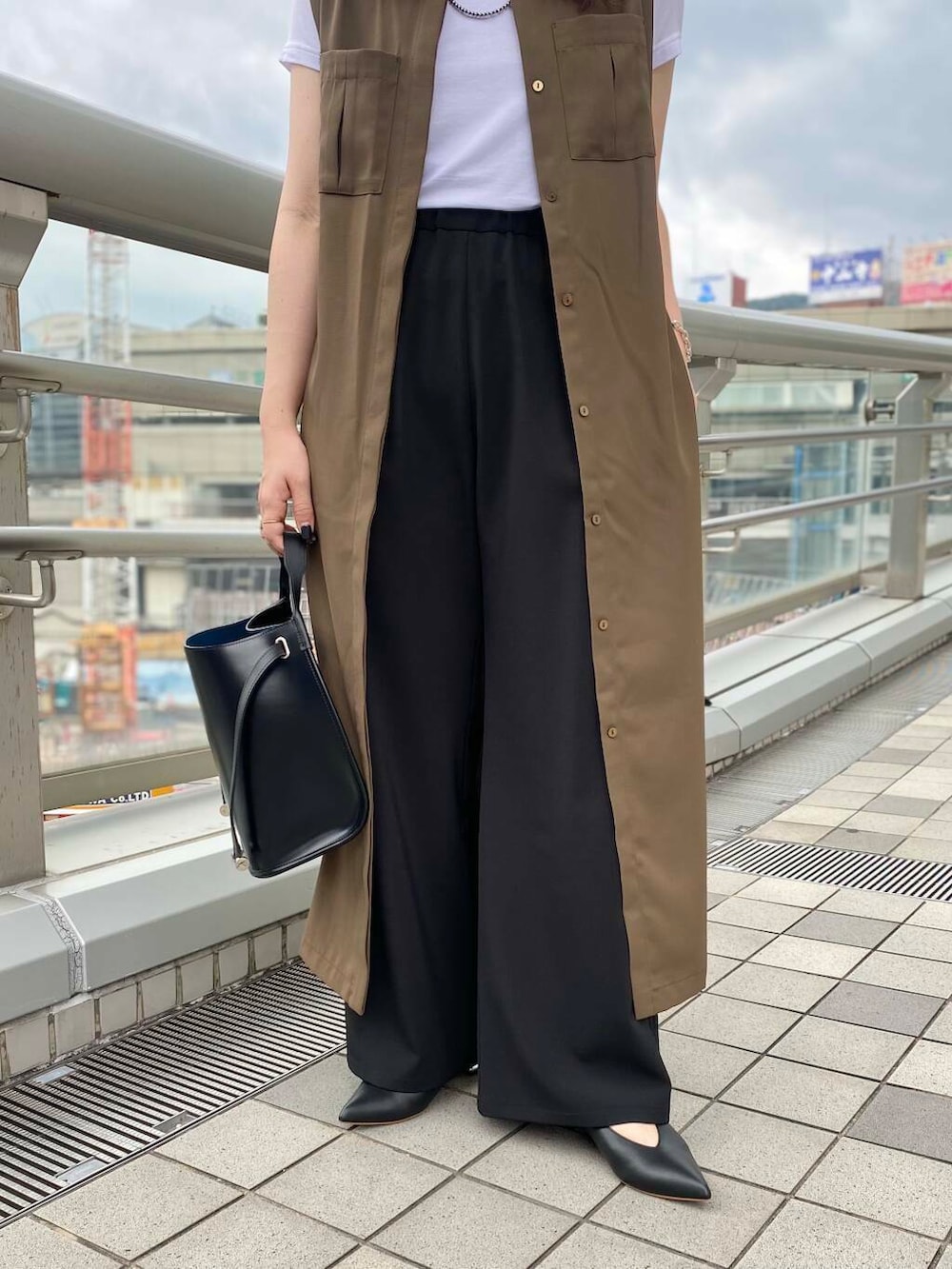 ブラック系のその他パンツ、ホワイト系のTシャツ/カットソー、ブラウン系のワンピースを着用したレディースの夏コーディネートの5枚目の写真