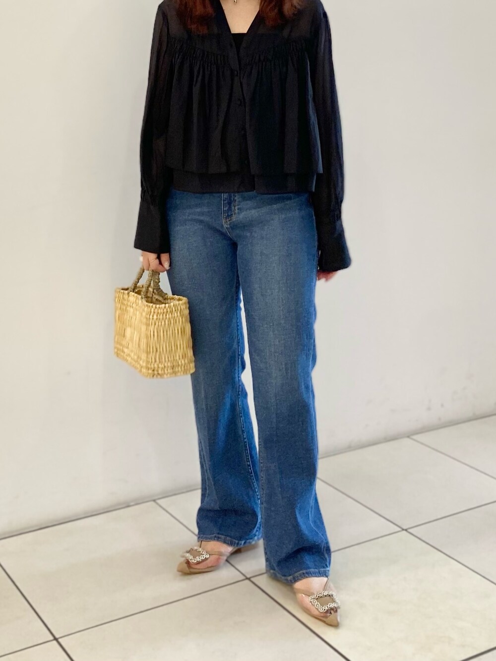 ブラック系のシャツ/ブラウス、ベージュ系のハンドバッグ、ブルー系のデニムパンツを着用したレディースの春コーディネートの7枚目の写真