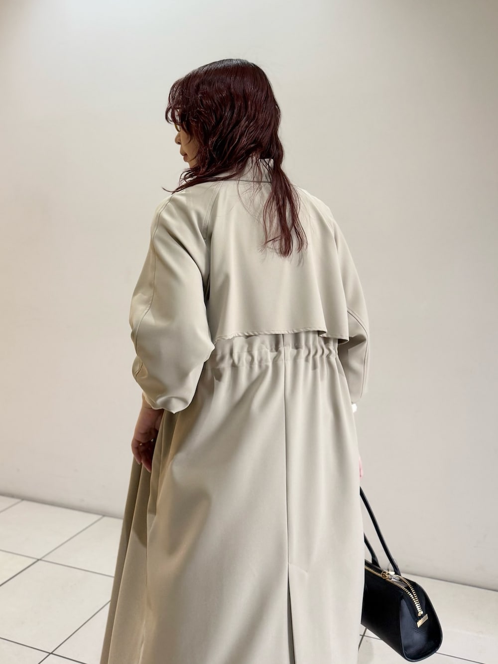 ベージュ系のトレンチコート、ホワイト系のニット/セーター、ブルー系のシャツ/ブラウスを着用したレディースの冬コーディネートの8枚目の写真