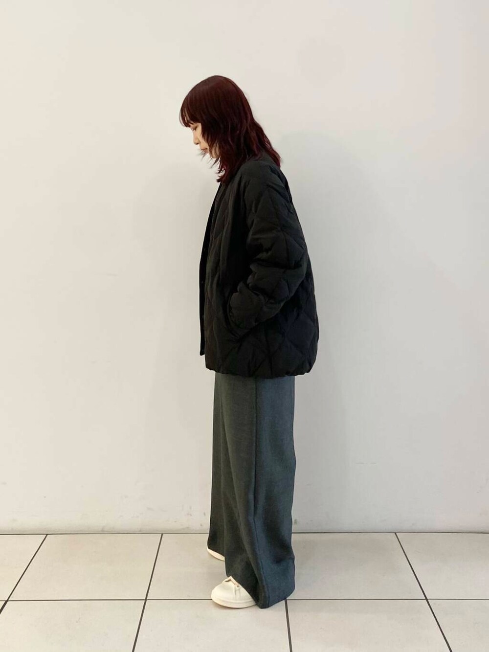 ブラック系のTシャツ/カットソー、ブラック系のダウンジャケット/コート、グレー系のサロペット/オーバーオールを着用したレディースの冬コーディネートの3枚目の写真