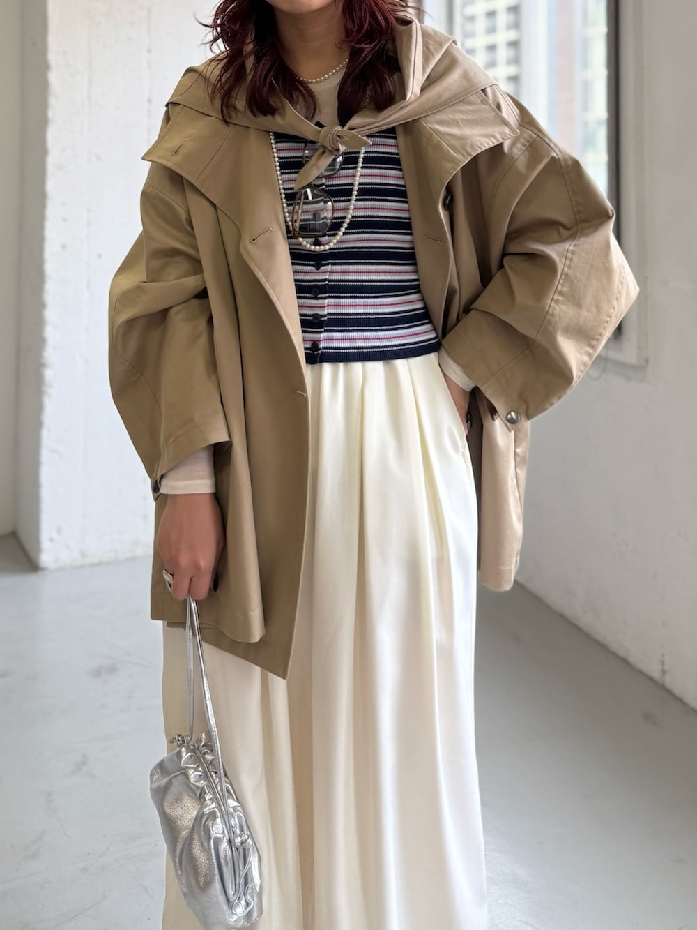 ホワイト系のその他パンツ、ベージュ系のトレンチコート、ブルー系のニット/セーターを着用したレディースの冬コーディネートの6枚目の写真