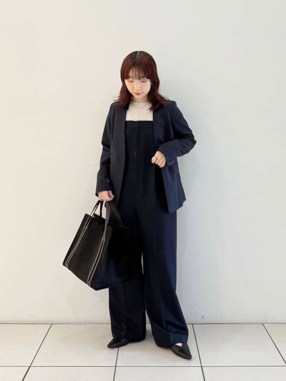 ブルー系のノーカラージャケット、ブルー系のサロペット/オーバーオール、グレー系のニット/セーターを着用したレディースの春コーディネートの2枚目の写真