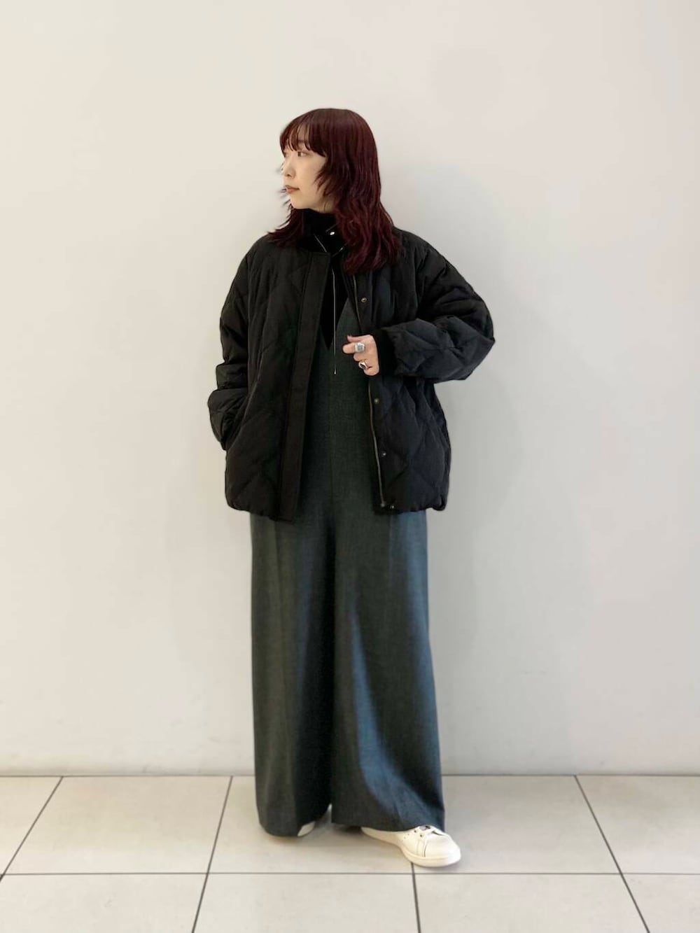 ブラック系のTシャツ/カットソー、ブラック系のダウンジャケット/コート、グレー系のサロペット/オーバーオールを着用したレディースの冬コーディネートの2枚目の写真