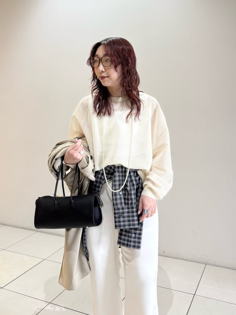 ベージュ系のトレンチコート、ホワイト系のニット/セーター、ブルー系のシャツ/ブラウスを着用したレディースの冬コーディネートの9枚目の写真