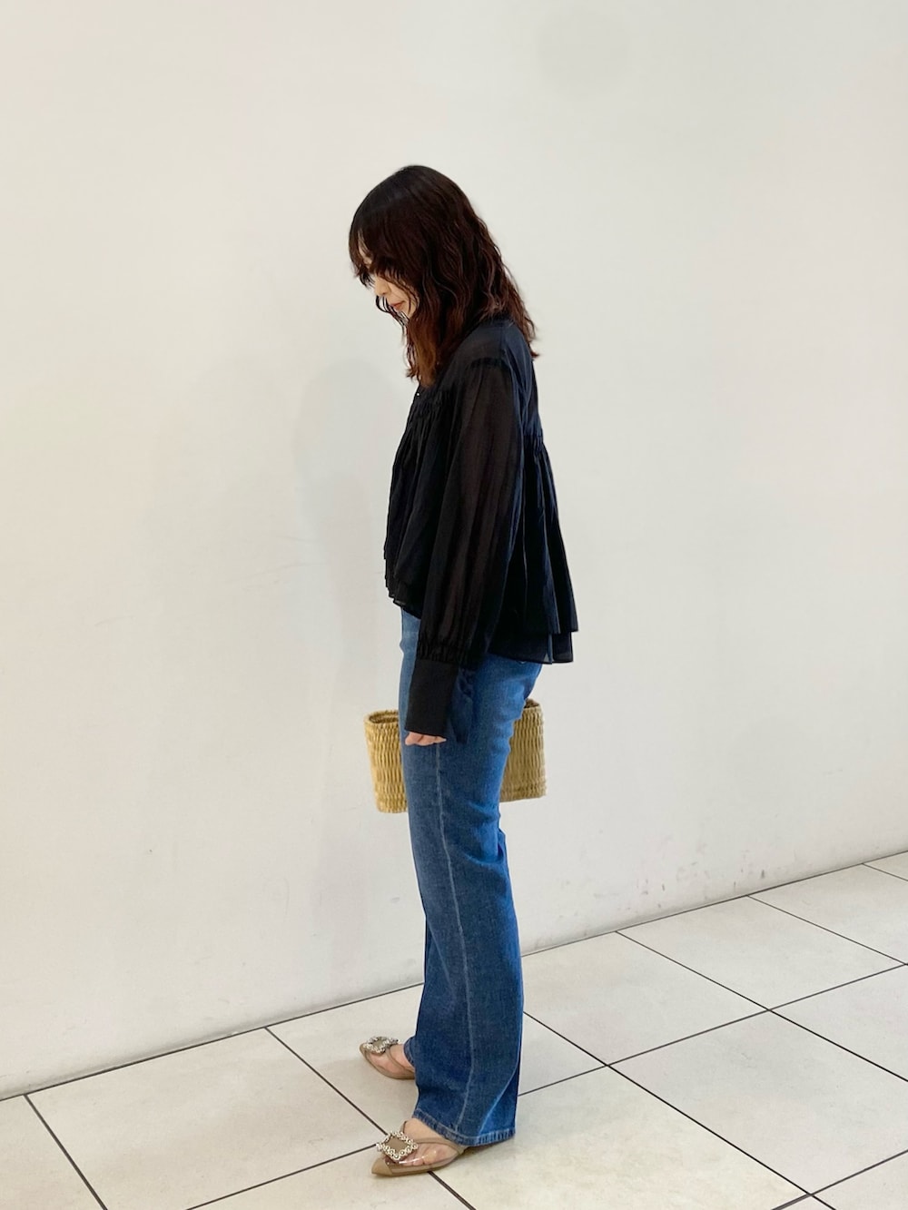 ブラック系のシャツ/ブラウス、ベージュ系のハンドバッグ、ブルー系のデニムパンツを着用したレディースの春コーディネートの4枚目の写真