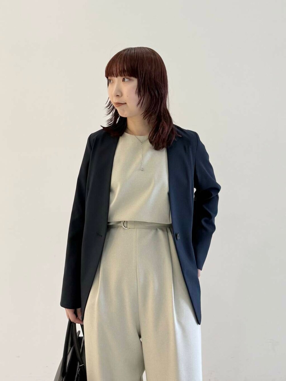 ベージュ系のサロペット/オーバーオール、ブルー系のノーカラージャケット、ブラック系のパンプスを着用したレディースの春コーディネートの6枚目の写真