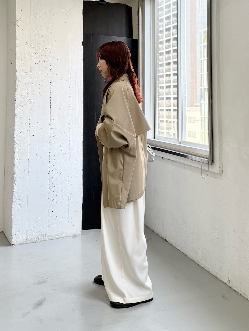 ホワイト系のその他パンツ、ベージュ系のトレンチコート、ブルー系のニット/セーターを着用したレディースの冬コーディネートの2枚目の写真