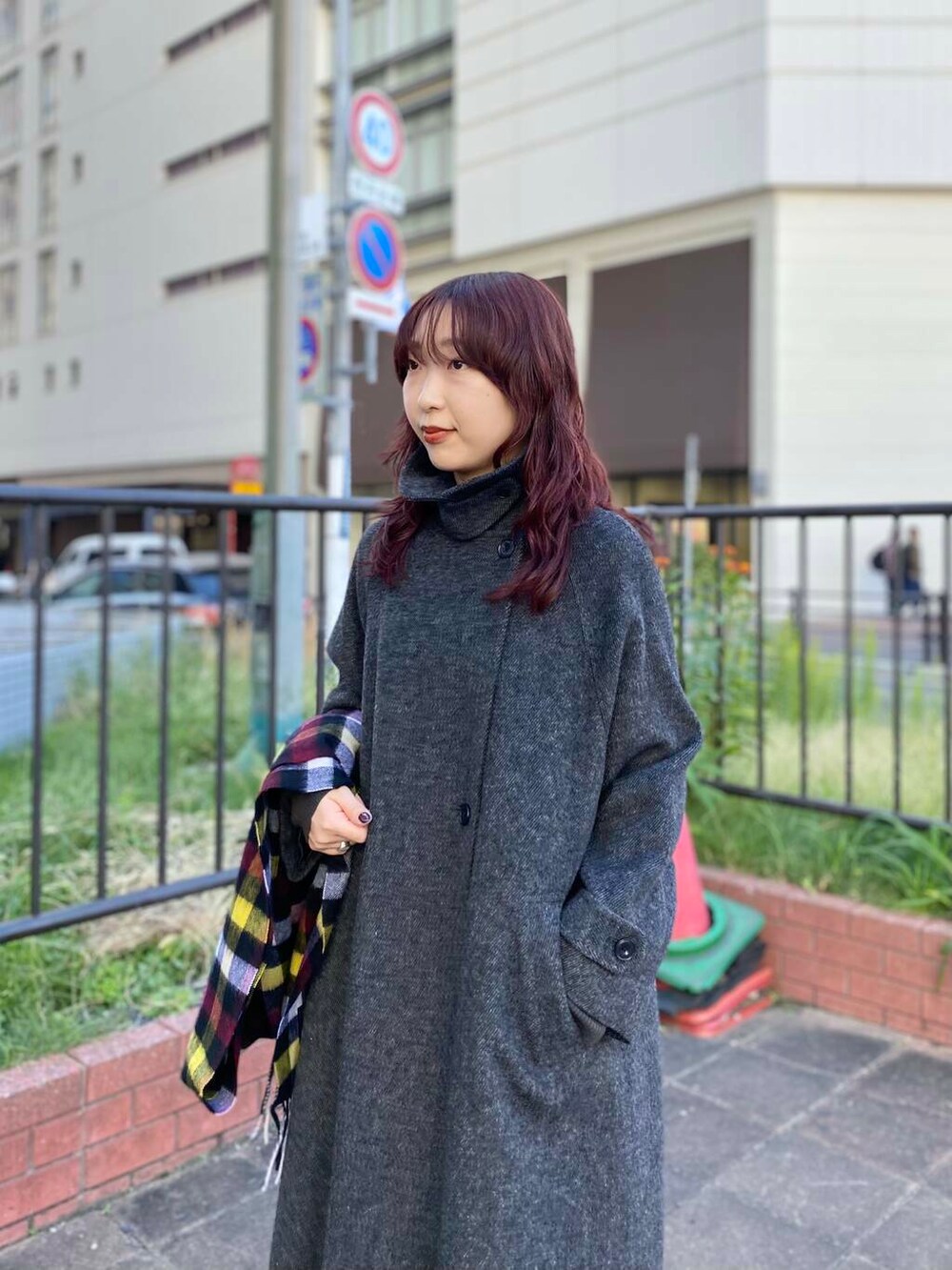 ブラック系のステンカラーコート、グリーン系のニット/セーター、ブラック系のブーツを着用したレディースの秋コーディネートの6枚目の写真