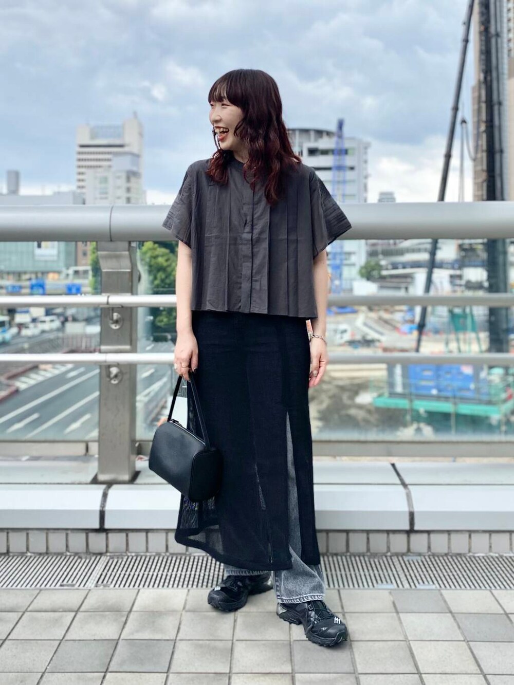 ブラック系のスカート、ブラック系のデニムパンツ、グレー系のシャツ/ブラウスを着用したレディースの夏コーディネートの2枚目の写真