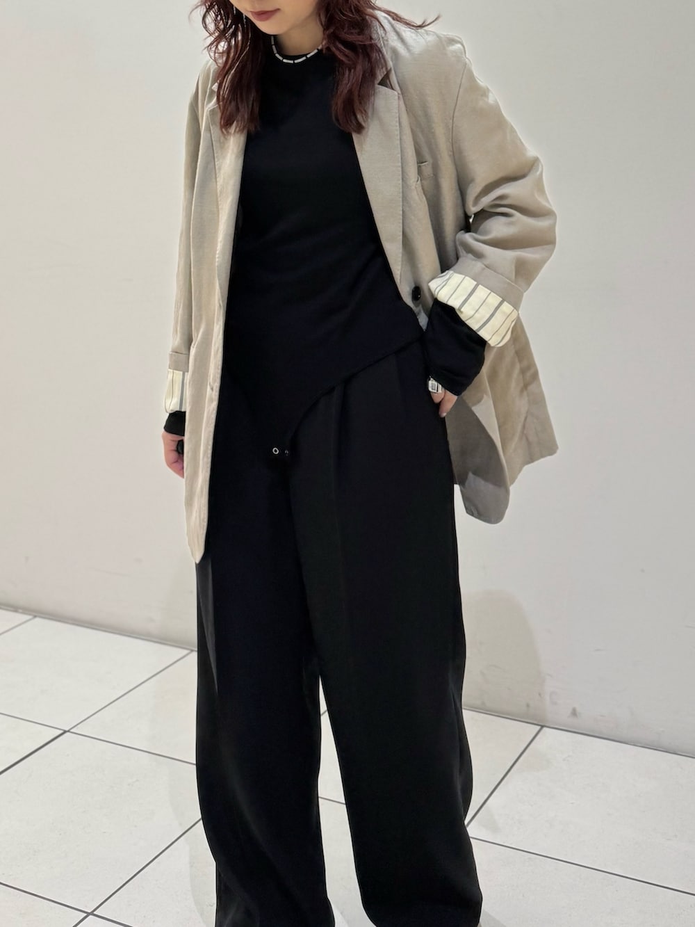 ブラック系のその他パンツ、ブラック系のTシャツ/カットソー、ベージュ系のテーラードジャケットを着用したレディースの冬コーディネートの6枚目の写真