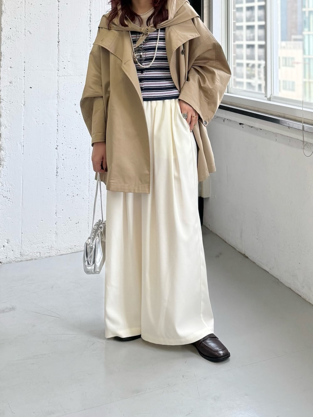 ホワイト系のその他パンツ、ベージュ系のトレンチコート、ブルー系のニット/セーターを着用したレディースの冬コーディネートの7枚目の写真