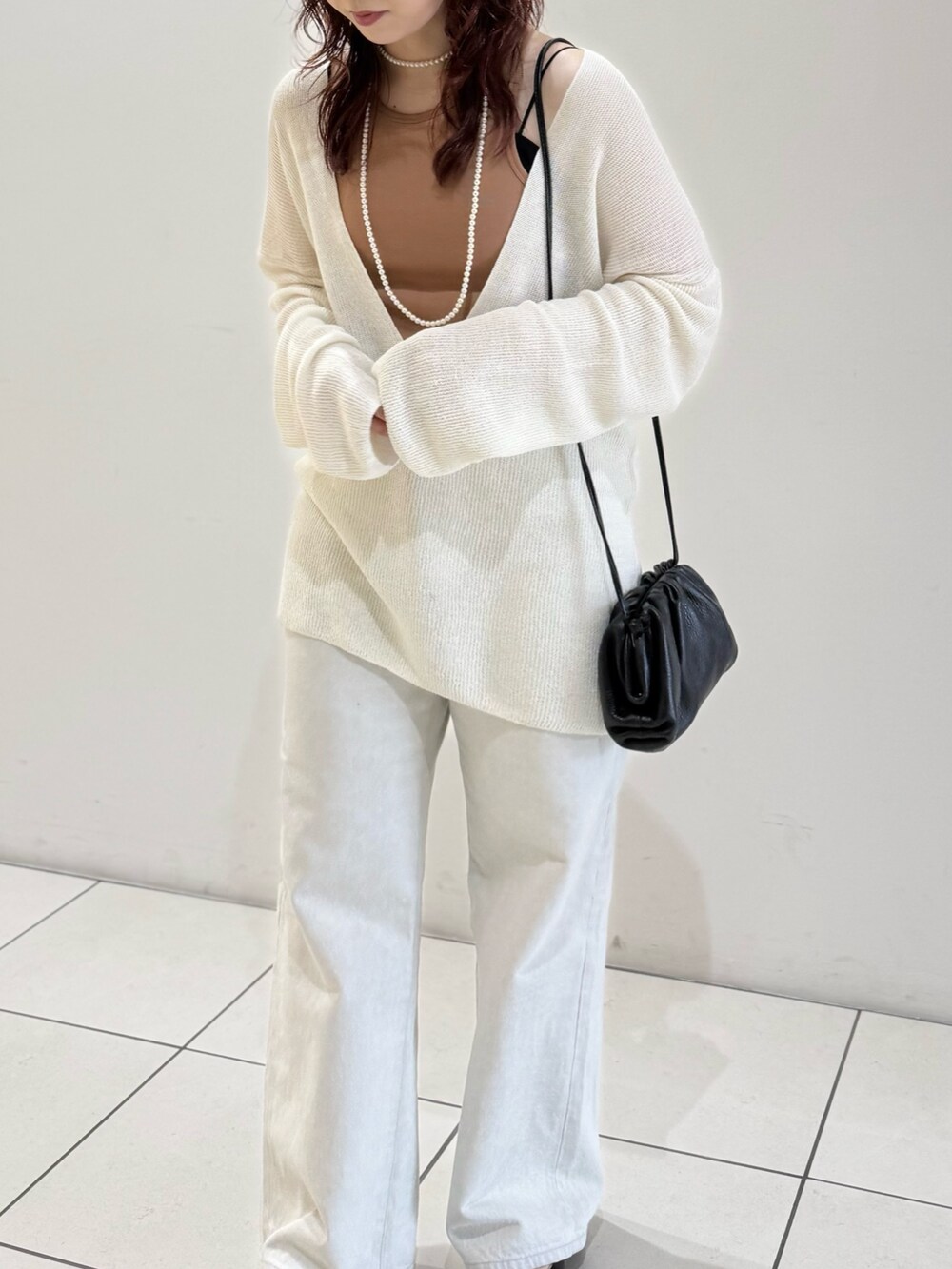 ブラック系のパンプス、オレンジ系のタンクトップ、ホワイト系のニット/セーターを着用したレディースの春コーディネートの7枚目の写真