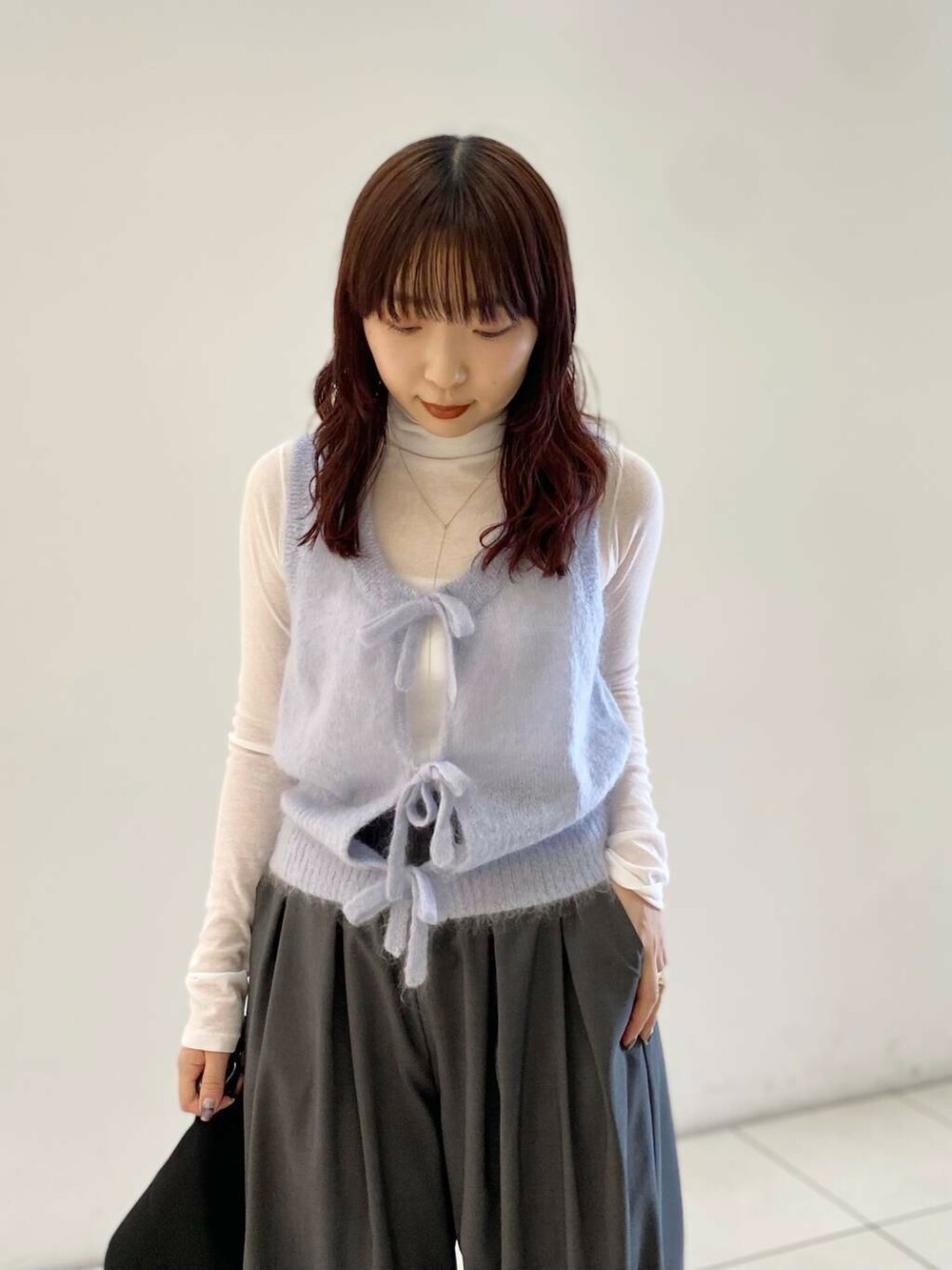ホワイト系のTシャツ/カットソー、グレー系のベスト、グレー系のその他パンツを着用したレディースの秋コーディネートの4枚目の写真