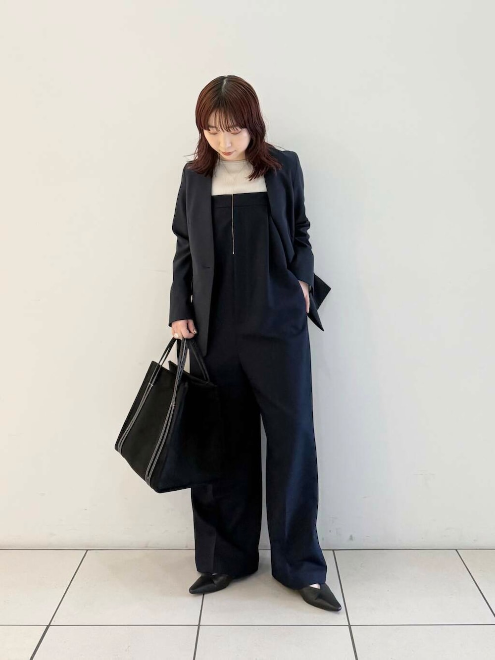 ブルー系のノーカラージャケット、ブルー系のサロペット/オーバーオール、グレー系のニット/セーターを着用したレディースの春コーディネートの3枚目の写真