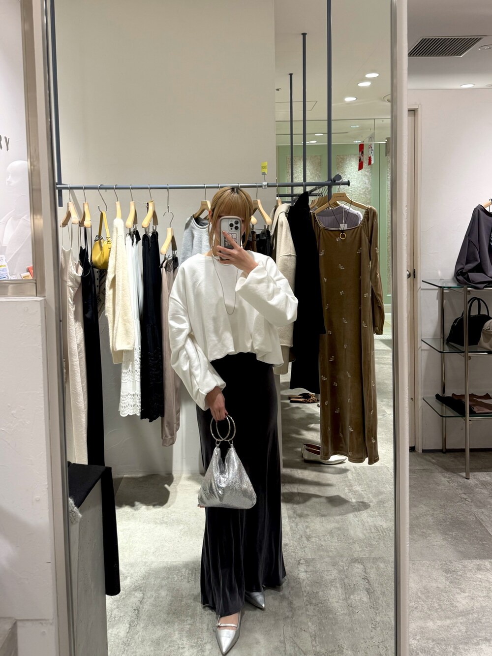 ホワイト系のTシャツ/カットソー、シルバー系のトートバッグ、グレー系のスカートを着用したレディースの冬コーディネートの3枚目の写真