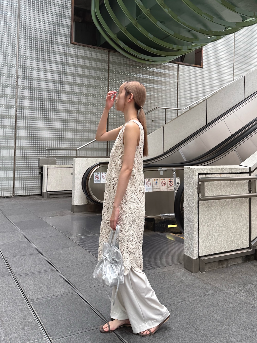 ホワイト系のチュニック、ホワイト系のその他パンツ、シルバー系のトートバッグを着用したレディースの夏コーディネートの2枚目の写真