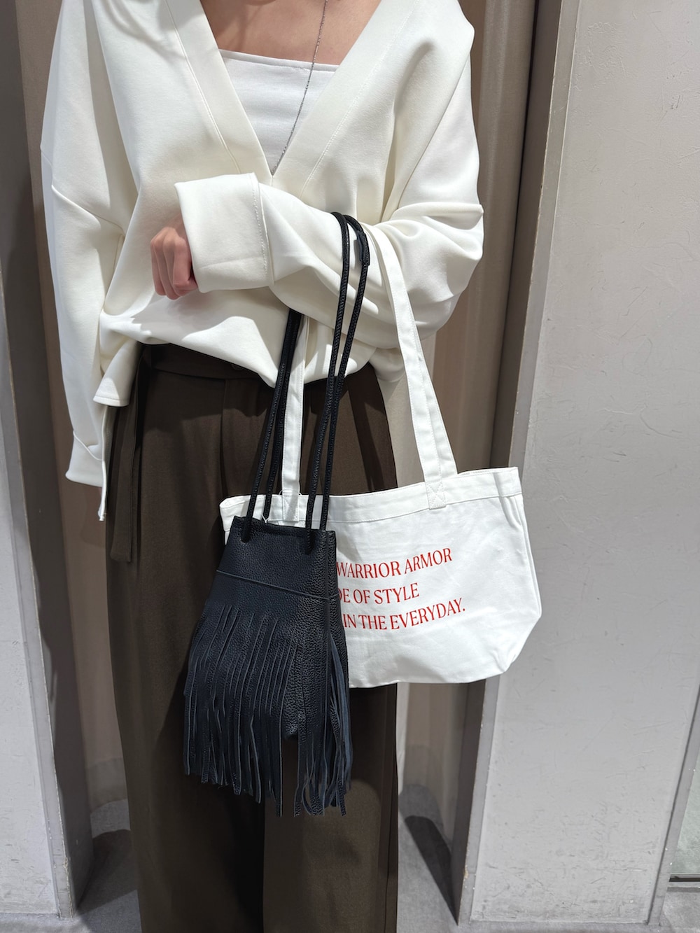 ブラウン系のその他パンツ、ホワイト系のトートバッグ、ブラック系のトートバッグを着用したレディースの秋コーディネートの2枚目の写真