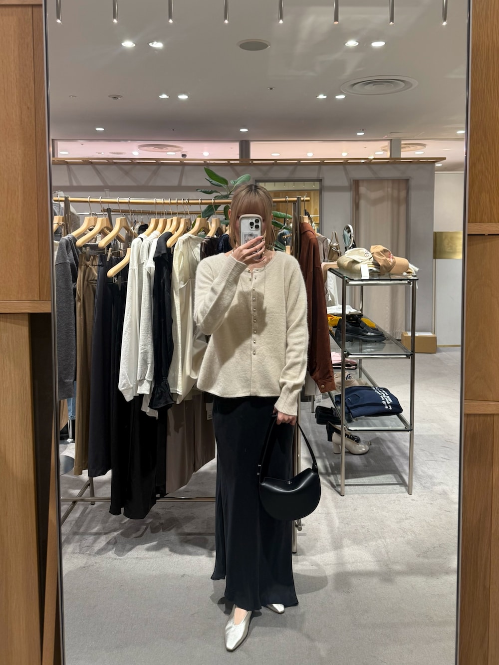 ホワイト系のカーディガン/ボレロ、ブラック系のトートバッグ、ブラック系のスカートを着用したレディースの秋コーディネートの3枚目の写真