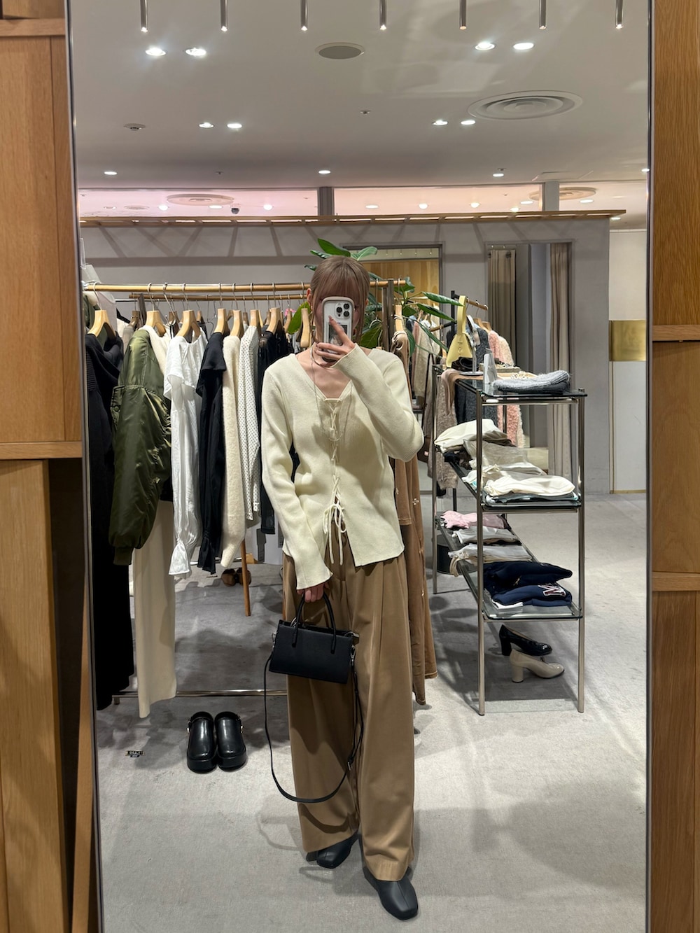 ブラック系のトートバッグ、ホワイト系のニット/セーター、ホワイト系のその他アウターを着用したレディースの冬コーディネートの2枚目の写真