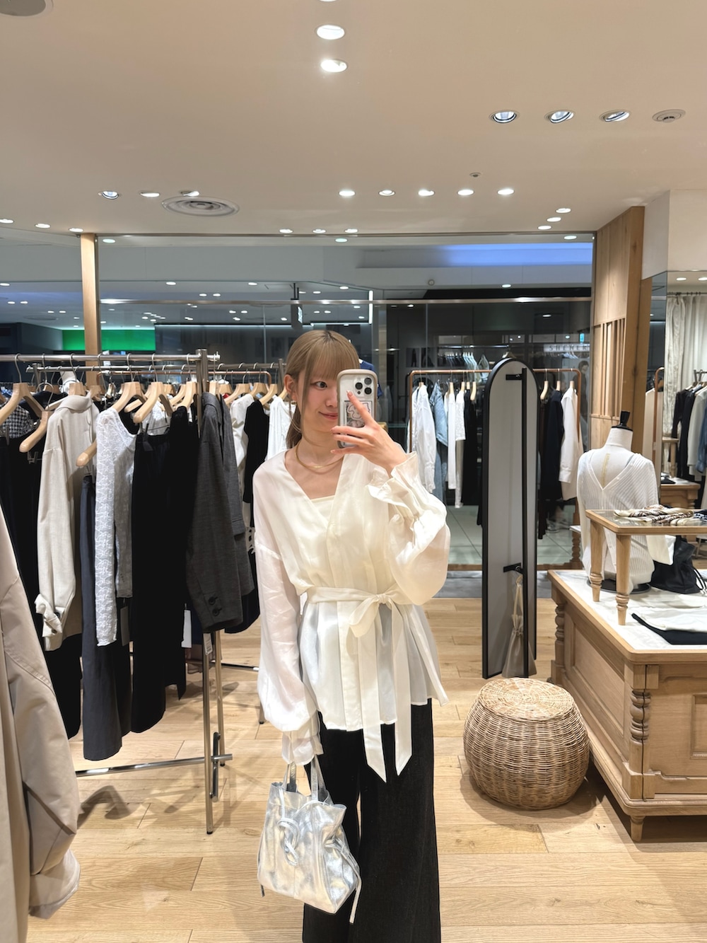 ホワイト系のシャツ/ブラウス、シルバー系のトートバッグ、ブルー系のデニムパンツを着用したレディースの春コーディネートの2枚目の写真