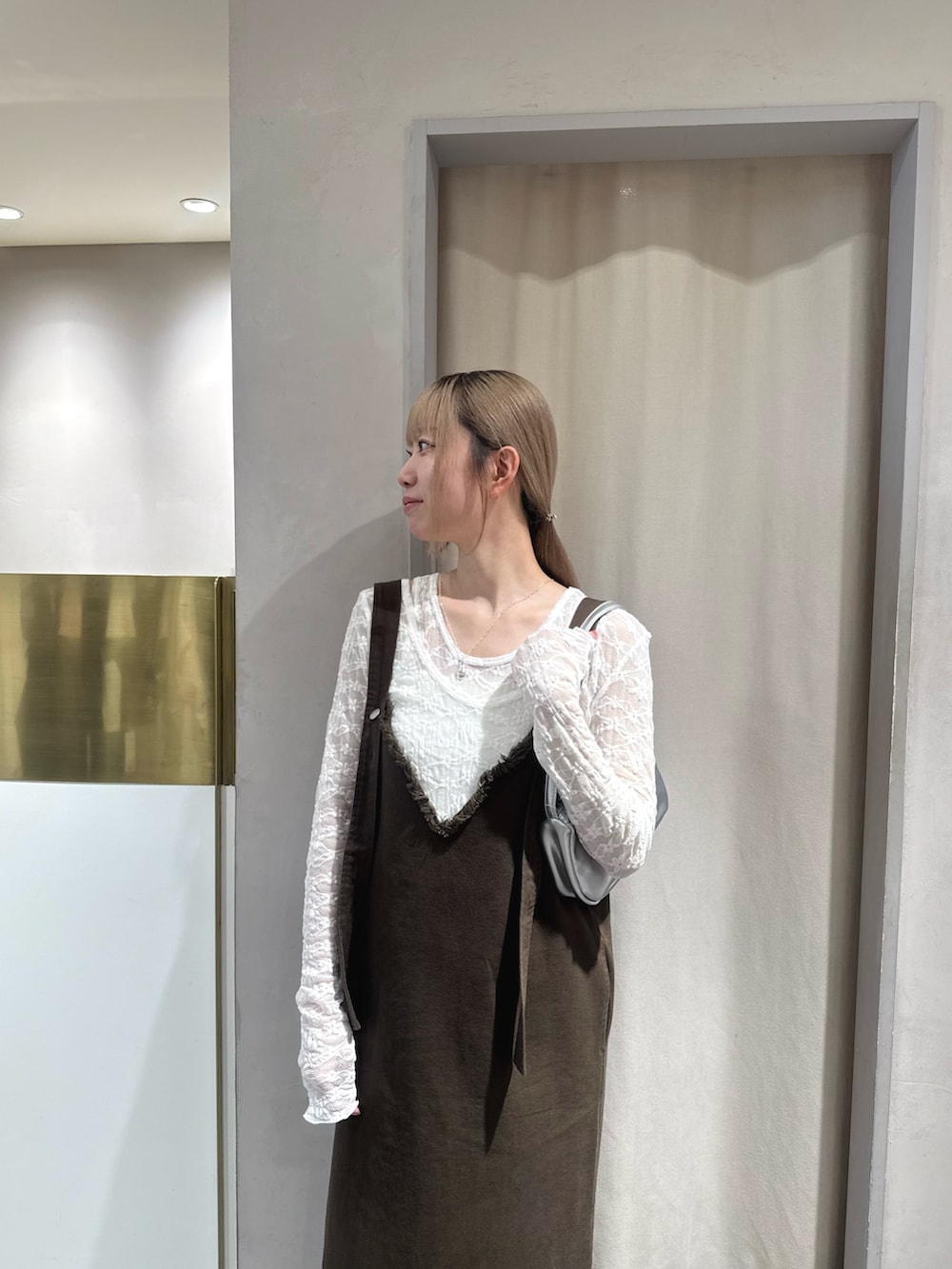 ブラウン系のワンピース、ホワイト系のTシャツ/カットソー、シルバー系のショルダーバッグを着用したレディースの夏コーディネートの4枚目の写真
