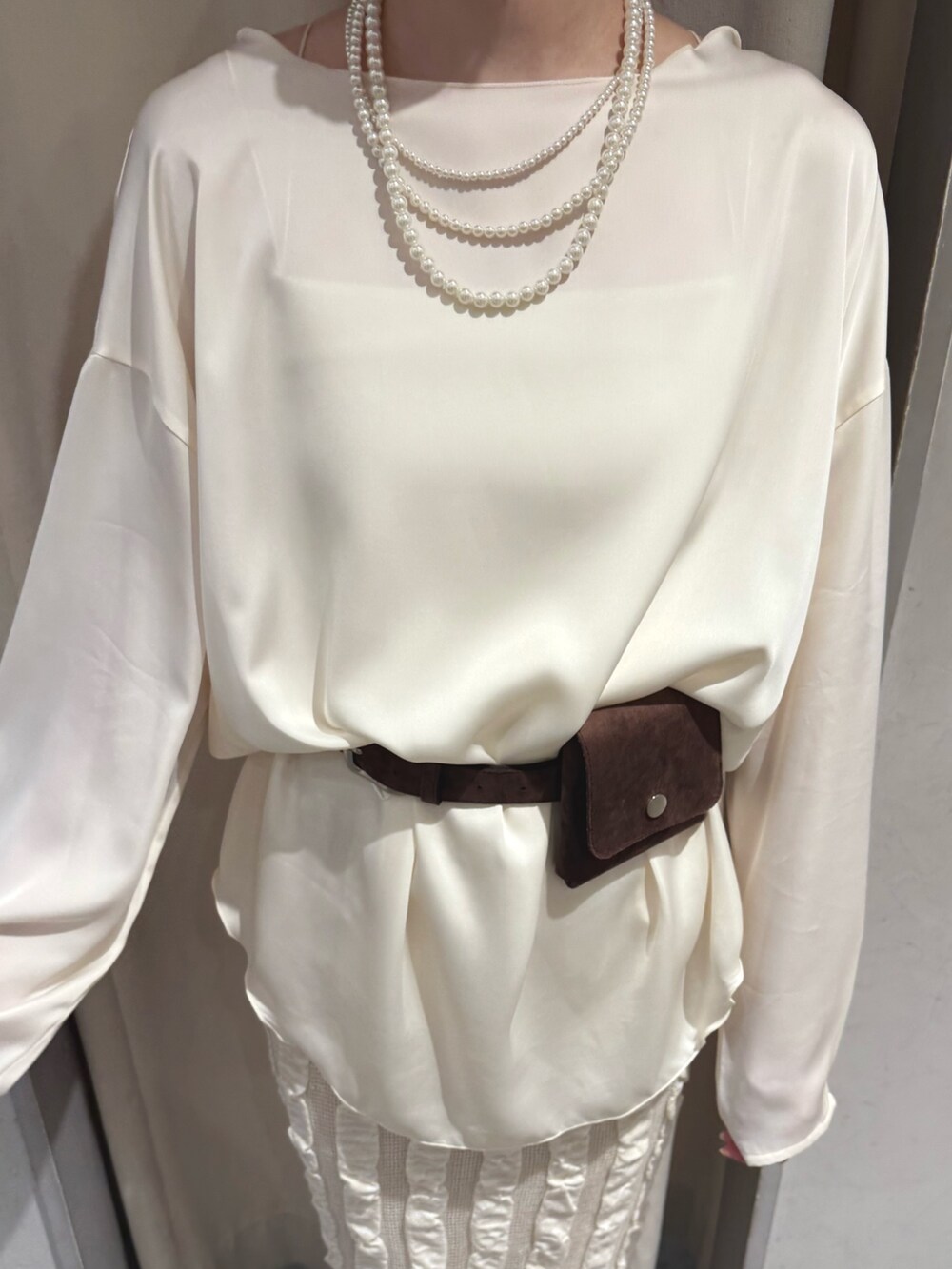 ベージュ系のスカート、ホワイト系のシャツ/ブラウス、ブラウン系のベルトを着用したレディースの春コーディネートの4枚目の写真