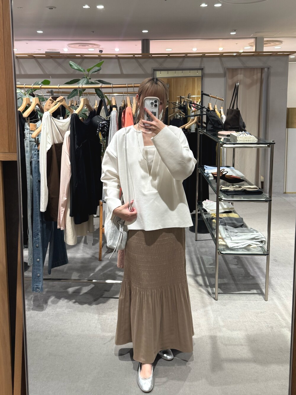 ホワイト系のスウェット、ホワイト系のキャミソール、ベージュ系のスカートを着用したレディースの秋コーディネートの3枚目の写真